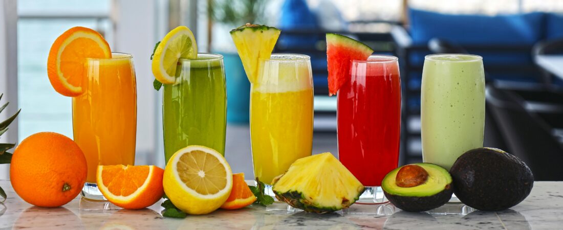 A vibrant array of fresh fruit juices with garnishes, offering a healthy and refreshing drink option.